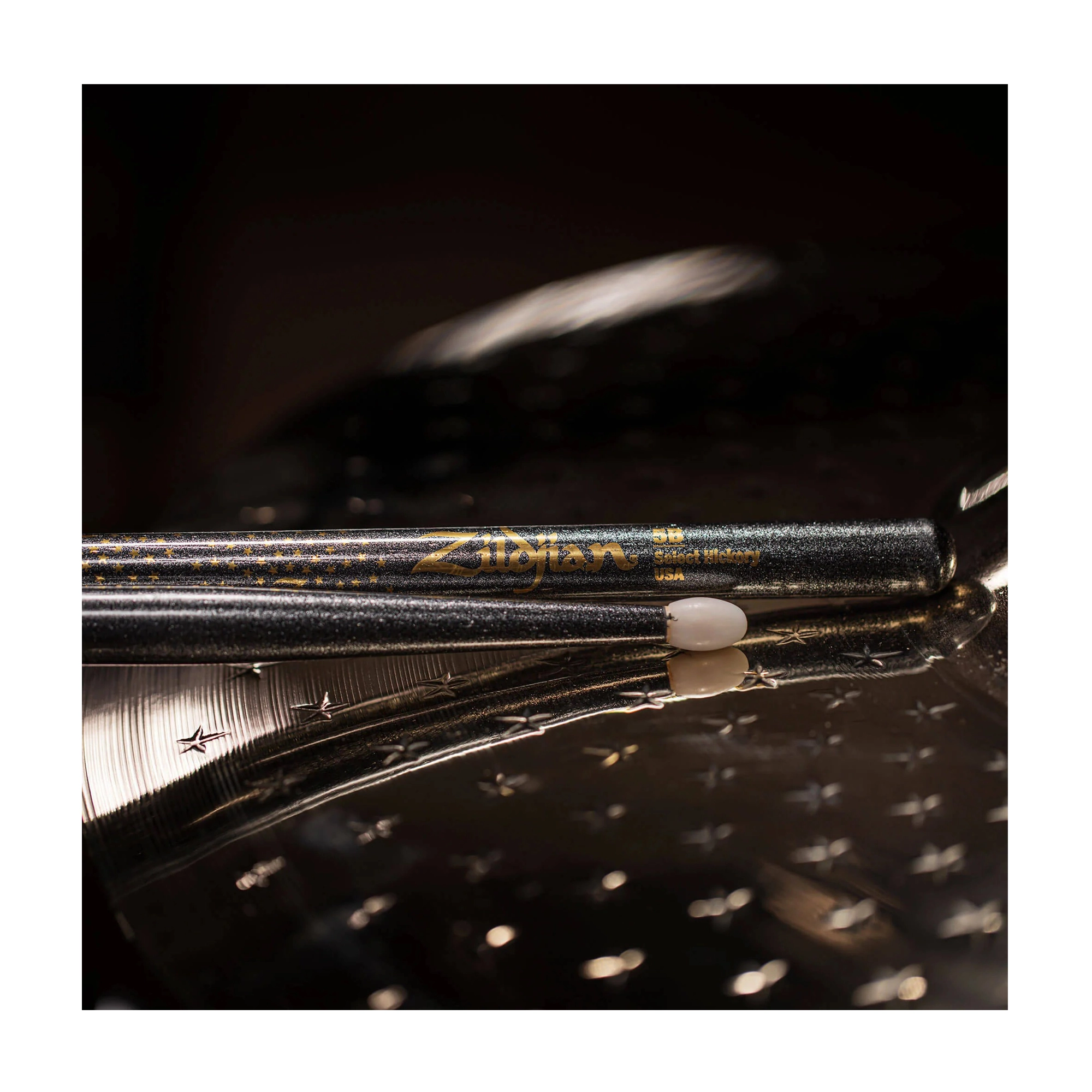 Pair of drumsticks on a drum surface with Zildjian branding.