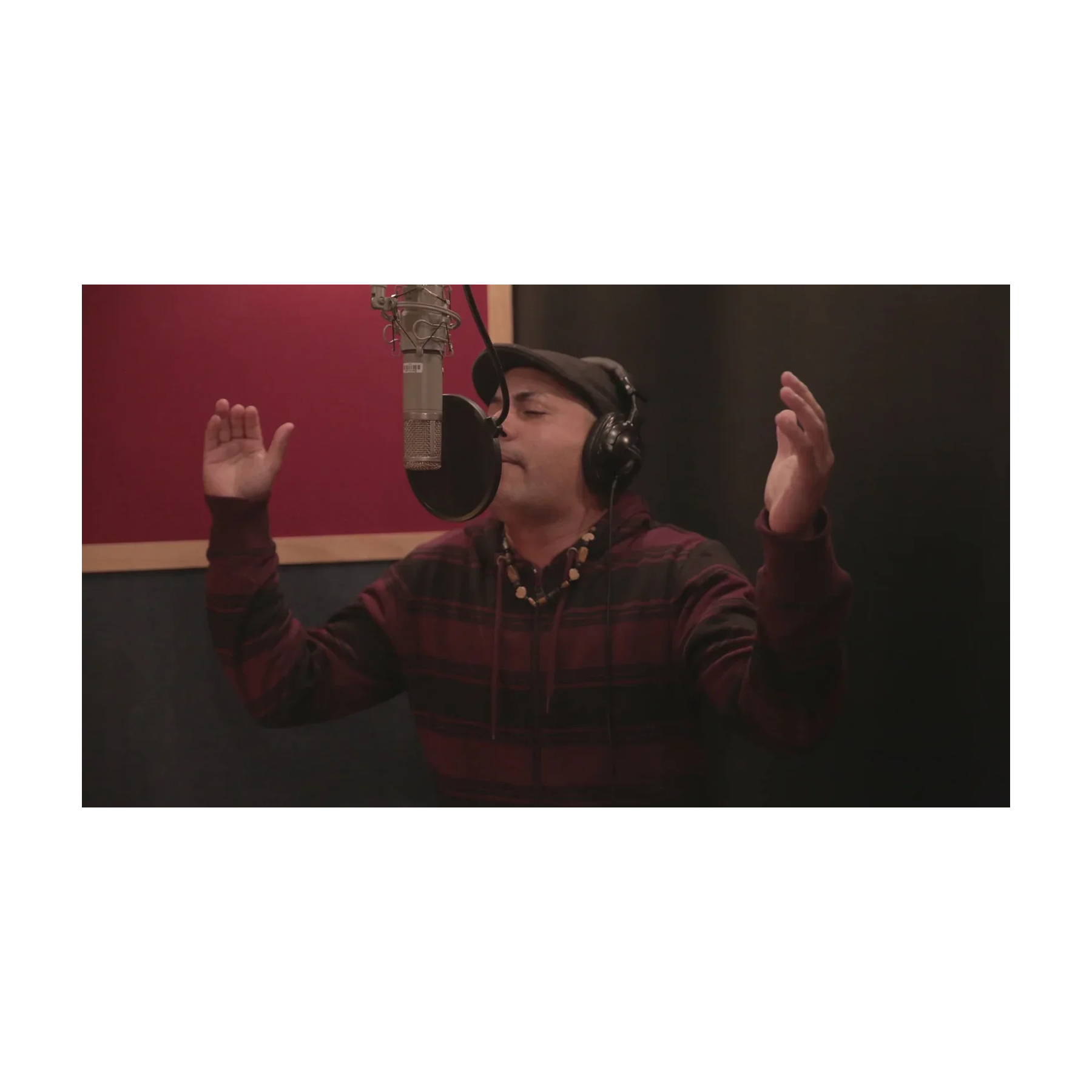 Person in a recording studio with headphones and microphone