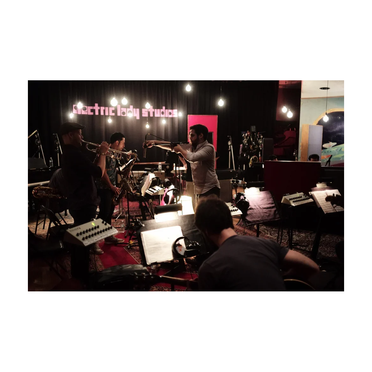 Band practice in a studio with musicians and instruments.