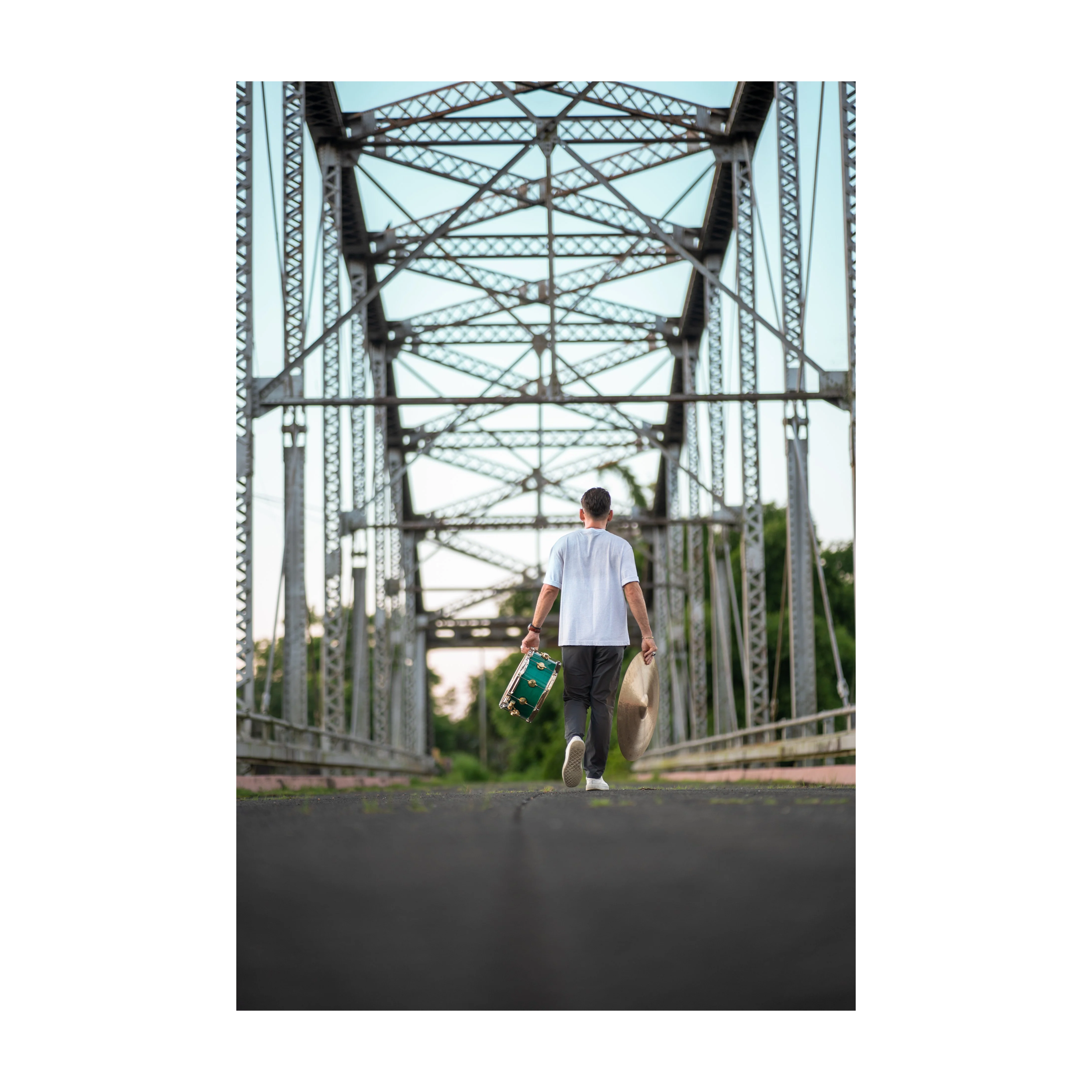 Person walking under a large metal bridge structure.