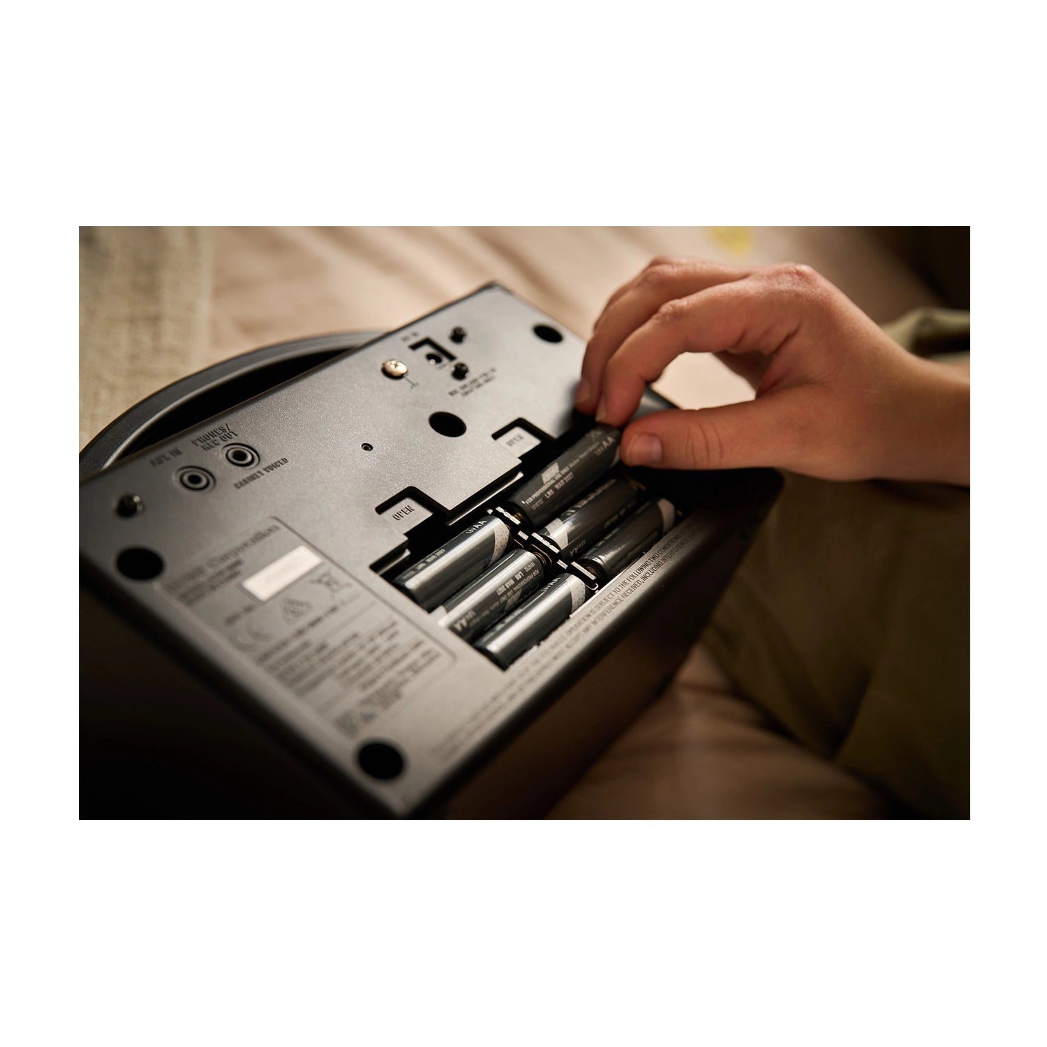 Person inserting batteries into Boss Katana 7W Mini Guitar Amp 